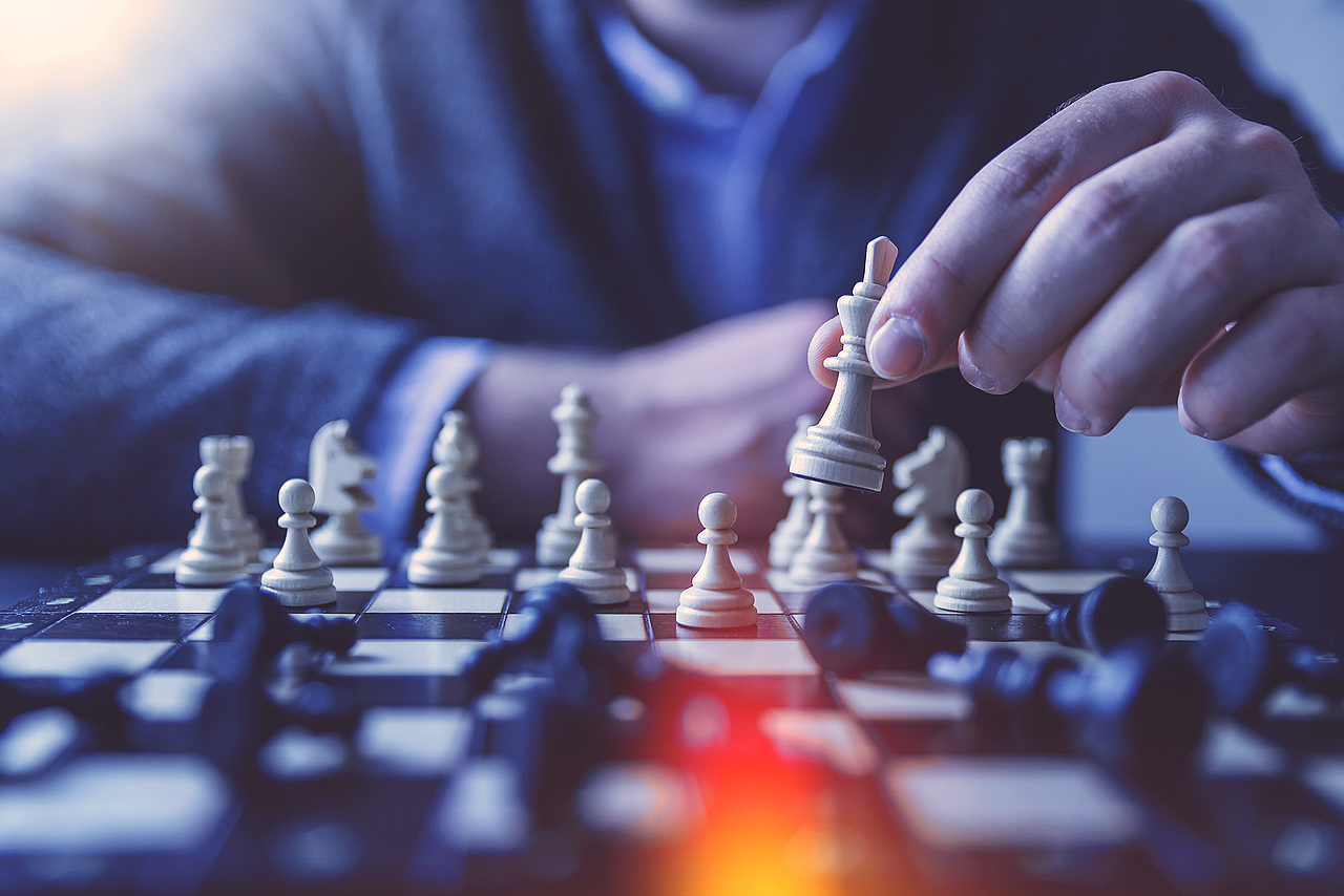 Eine Person spielt Schach, welches die UX-Strategie symbolisiert.