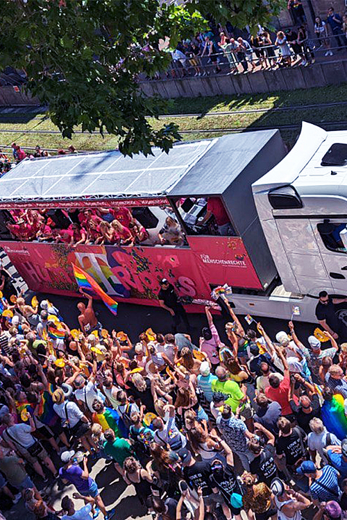 CSD Pride Wagen der Deutschen Telekom mit feiernden Menschen auf der Straße